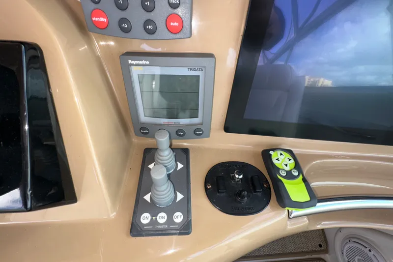 Slide: The Image of Control panel of a 2003 Carver 466 Motor Yacht with navigation and thruster controls. - 62