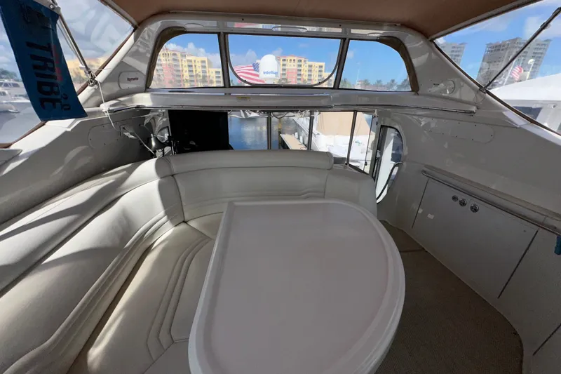 Slide: The Image of Interior of 2003 Carver 466 Motor Yacht with white seating and table, marina view. - 53