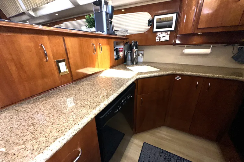 Slide: The Image of Luxurious kitchen interior of 2003 Carver 466 Motor Yacht with wooden cabinets and granite countertops. - 21