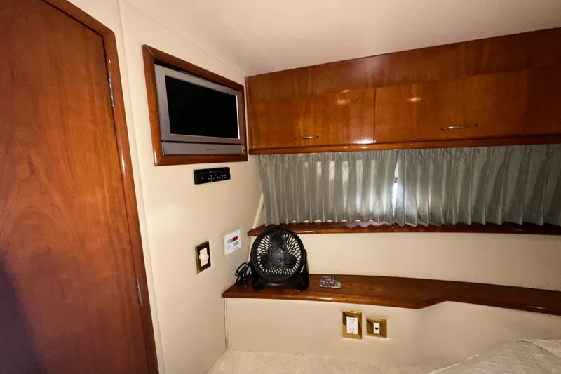 Slide: The Image of Interior of 2003 Carver 466 Motor Yacht with TV, fan, and wooden cabinetry. - 15