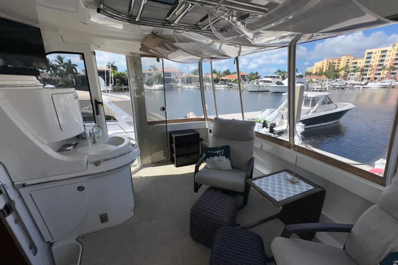 Slide: The Image of Interior of 2003 Carver 466 Motor Yacht with marina view, featuring seating and kitchenette. - 73