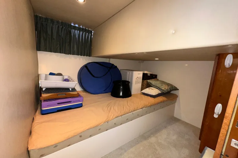 Slide: The Image of 2003 Carver 466 Motor Yacht cabin with storage items on a bed. - 19