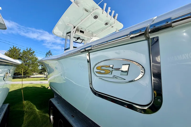 Slide: The Image of 2017 Sea Hunt Gamefish 30CB boat with SH logo, under clear blue sky. - 17
