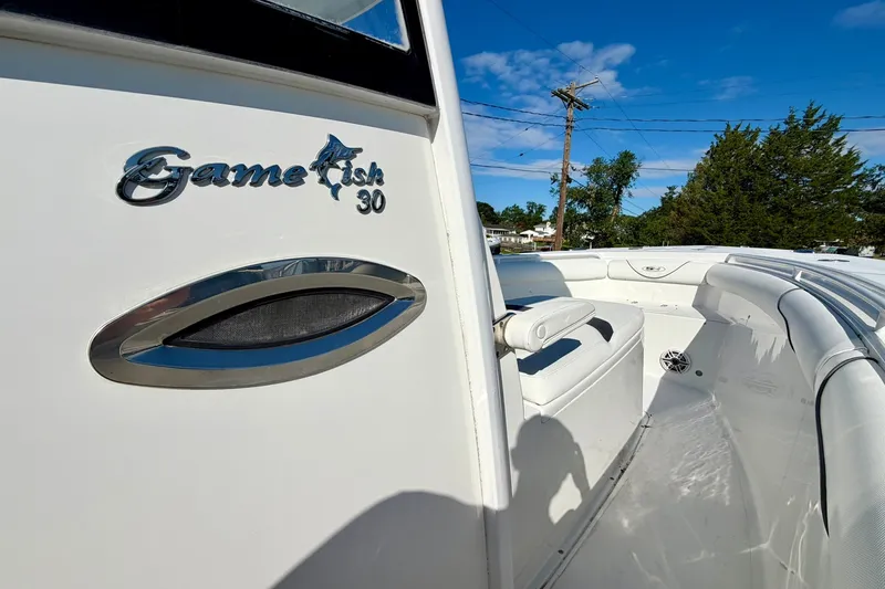 Slide: The Image of 2017 Sea Hunt Gamefish 30CB boat interior with seating, under clear blue sky. - 13