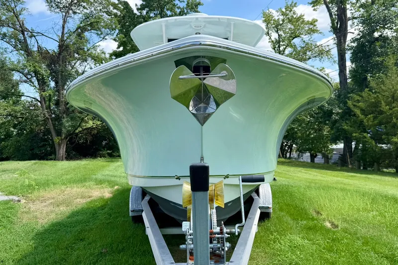 Slide: The Image of 2017 Sea Hunt Gamefish 30CB boat on trailer, surrounded by lush greenery. - 19