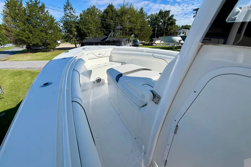 Slide: The Image of 2017 Sea Hunt Gamefish 30CB boat interior with seating, surrounded by greenery. - 14