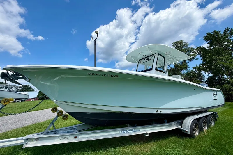 The Image of 2017 Sea Hunt Gamefish 30CB boat on trailer under blue sky. - 0