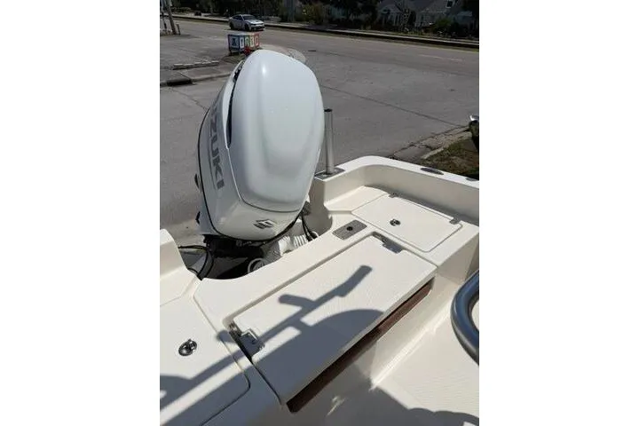 Slide: The Image of 2025 Pioneer 220 Bay Sport boat with Suzuki outboard motor at a dockside location. - 24