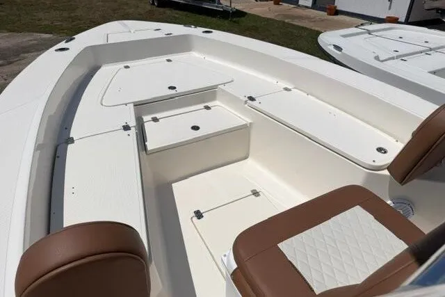 Slide: The Image of 2025 Pioneer 220 Bay Sport boat interior with white deck and brown seating. - 11