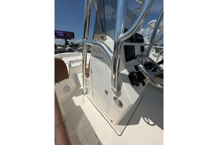 Slide: The Image of 2025 Pioneer 220 Bay Sport boat console with steering wheel and chrome details. - 29