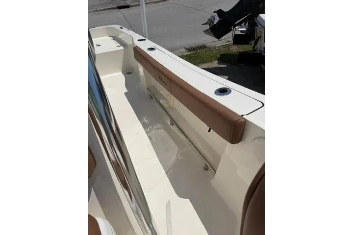Slide: The Image of 2025 Pioneer 220 Bay Sport boat interior with cushioned seating and cup holders. - 20