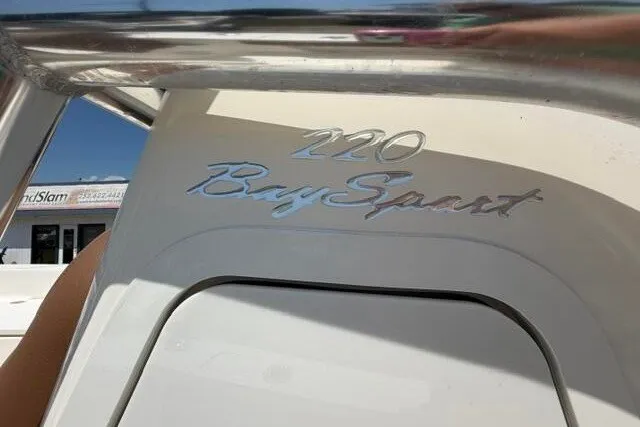 Slide: The Image of 2025 Pioneer 220 Bay Sport boat logo on white surface, under sunny sky. - 31
