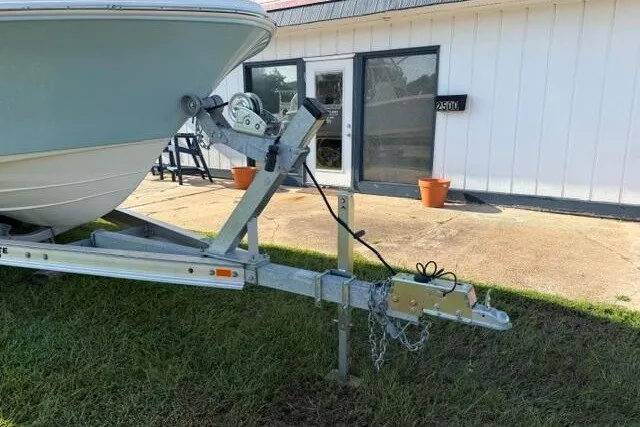 Slide: The Image of 2025 Pioneer 220 Bay Sport boat on trailer near building entrance. - 3