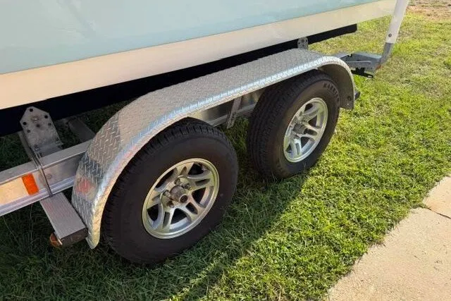Slide: The Image of Trailer wheels of 2025 Pioneer 220 Bay Sport boat on grass. - 7
