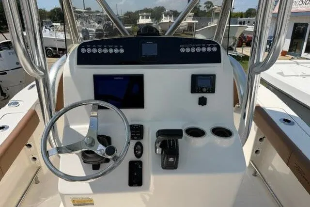 Slide: The Image of Control panel of 2025 Pioneer 220 Bay Sport boat with steering wheel and navigation instruments. - 33