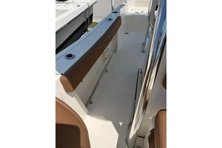 Slide: The Image of 2025 Pioneer 220 Bay Sport boat interior with brown seating and stainless steel railings. - 19