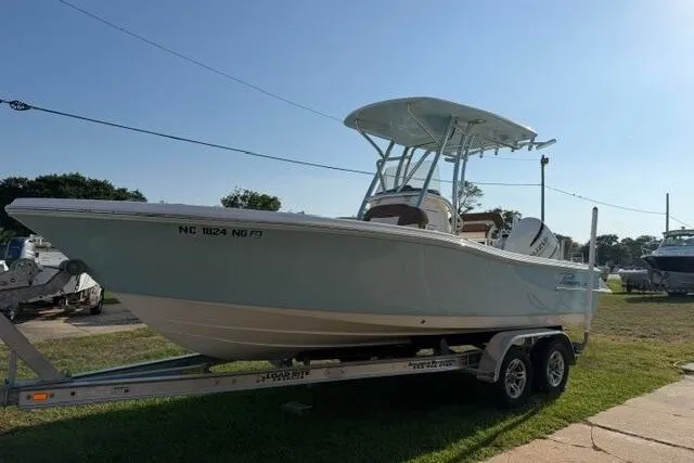 Slide: The Image of 2025 Pioneer 220 Bay Sport boat on trailer, parked outdoors under clear sky. - 5