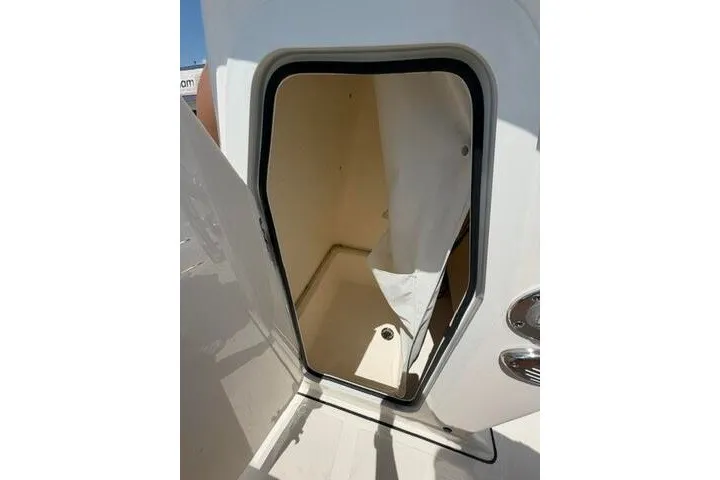 Slide: The Image of 2025 Pioneer 220 Bay Sport boat interior compartment with open door. - 30