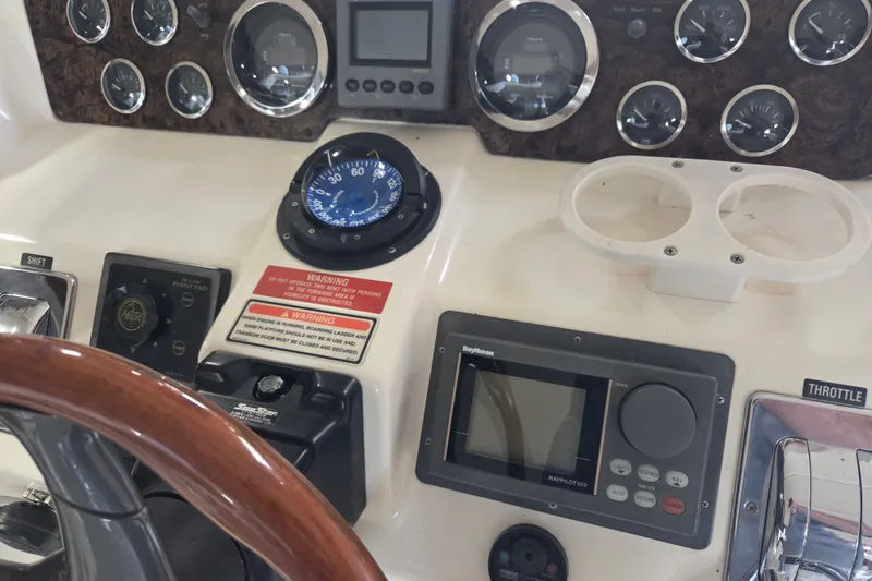 Slide: The Image of 1997 Sea Ray 440 Express Bridge dashboard with gauges, compass, and navigation controls. - 7
