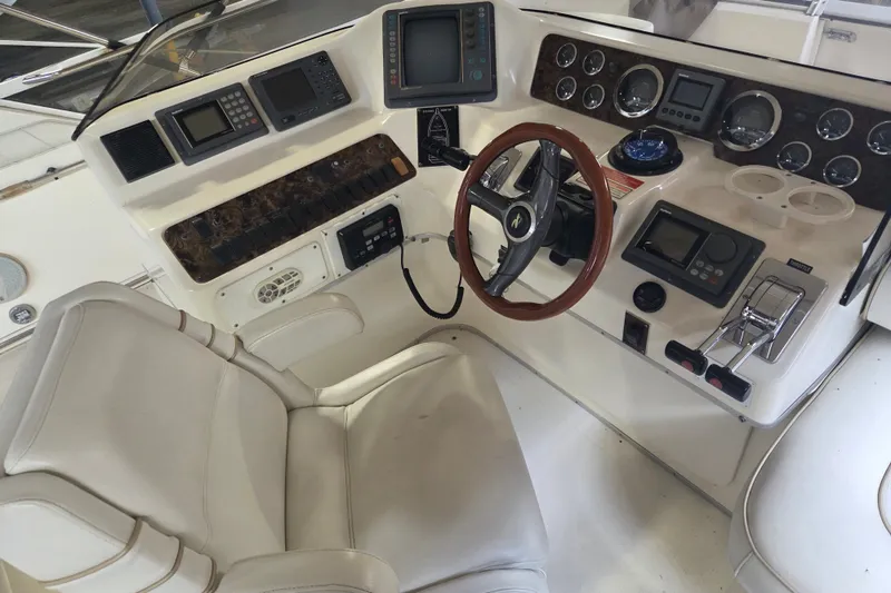 Slide: The Image of 1997 Sea Ray 440 Express Bridge helm with advanced navigation controls and luxurious seating. - 6