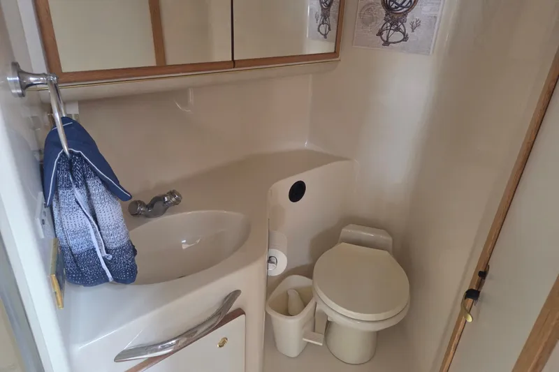 Slide: The Image of Bathroom interior of 1997 Sea Ray 440 Express Bridge yacht, featuring sink and toilet. - 21