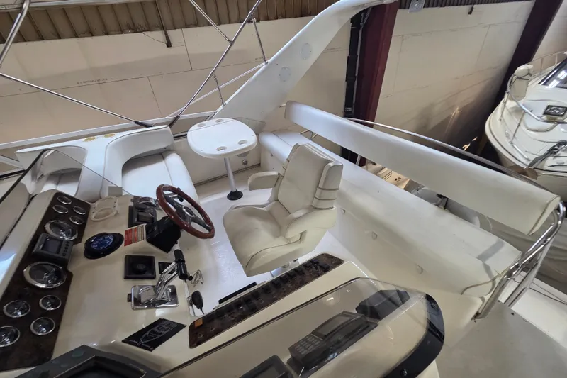 Slide: The Image of 1997 Sea Ray 440 Express Bridge cockpit with steering wheel, controls, and seating. - 9