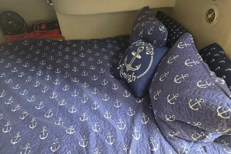 Slide: The Image of Nautical-themed bedding with anchor patterns in a 1997 Sea Ray 440 Express Bridge cabin. - 27