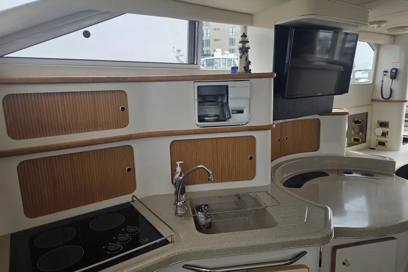 Slide: The Image of Interior of 1997 Sea Ray 440 Express Bridge yacht with kitchen and TV. - 20