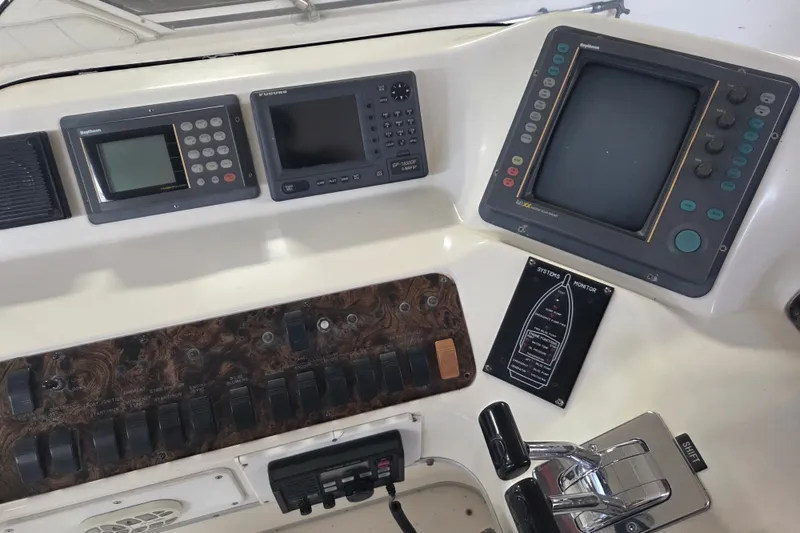 Slide: The Image of 1997 Sea Ray 440 Express Bridge helm with navigation and control panels. - 8