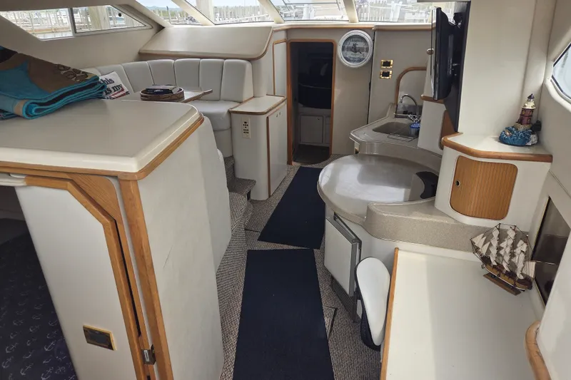 Slide: The Image of Interior of 1997 Sea Ray 440 Express Bridge yacht, featuring seating and kitchenette. - 12