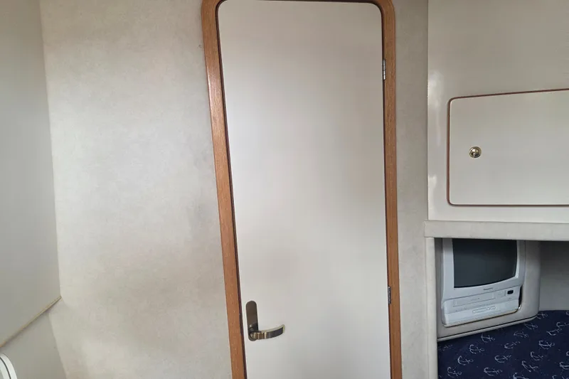 Slide: The Image of Interior of 1997 Sea Ray 440 Express Bridge with door and built-in TV cabinet. - 28