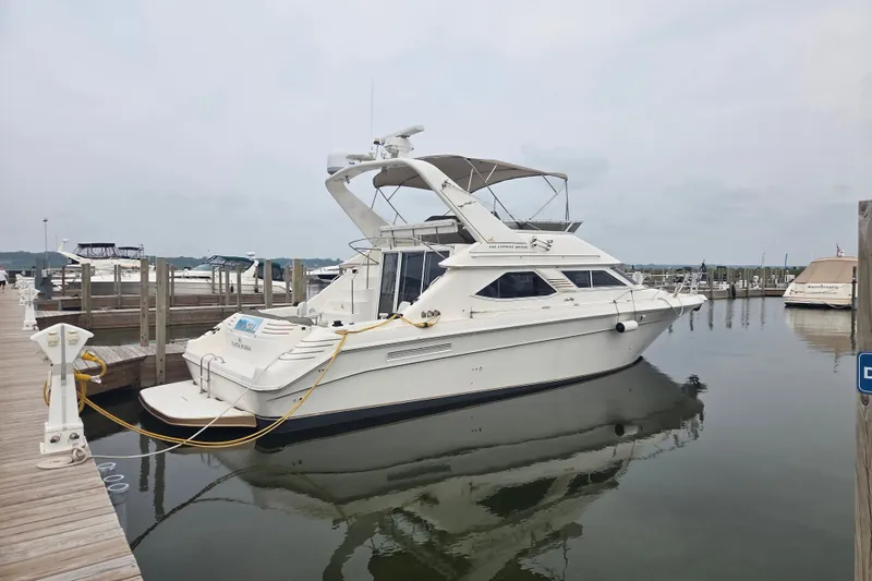 Slide: The Image of 1997 Sea Ray 440 Express Bridge yacht docked at a marina on a calm day. - 37