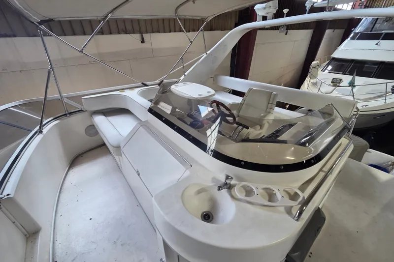 Slide: The Image of 1997 Sea Ray 440 Express Bridge yacht interior with helm and seating area. - 13