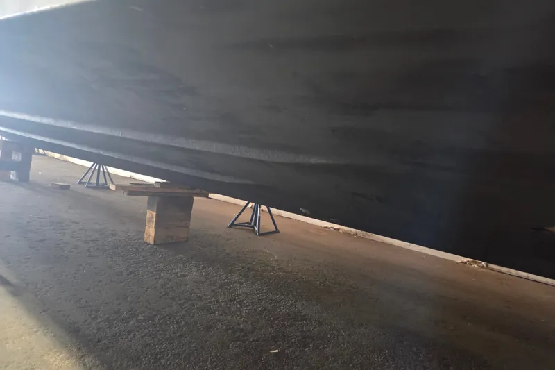 Slide: The Image of 1997 Sea Ray 440 Express Bridge hull on supports in a dry dock. - 35