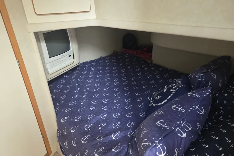 Slide: The Image of Cozy cabin interior of 1997 Sea Ray 440 Express Bridge with nautical-themed bedding. - 26