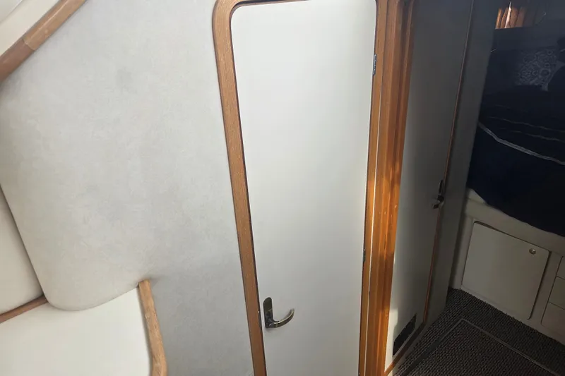 Slide: The Image of Interior view of 1997 Sea Ray 440 Express Bridge cabin with door and carpeted floor. - 24