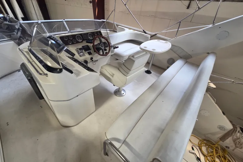 Slide: The Image of 1997 Sea Ray 440 Express Bridge helm with seating and controls in a clean, spacious layout. - 11