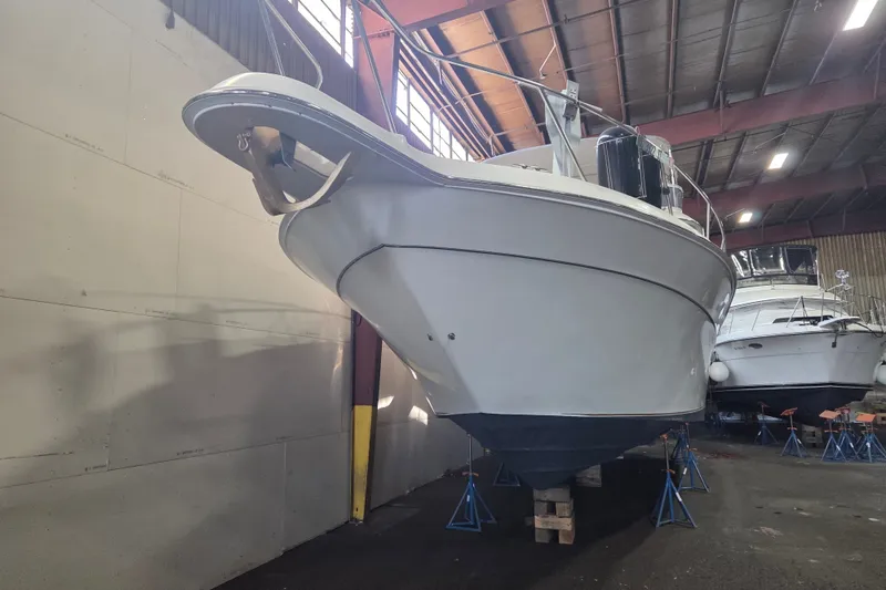 Slide: The Image of 1997 Sea Ray 440 Express Bridge yacht in indoor storage, elevated on stands. - 36