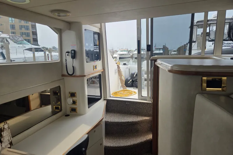 Slide: The Image of Interior view of 1997 Sea Ray 440 Express Bridge yacht, featuring elegant design and marina backdrop. - 19
