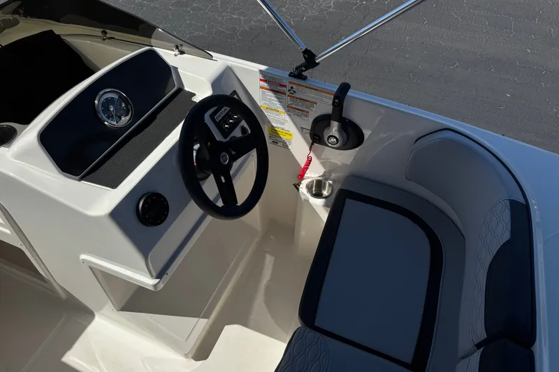 Slide: The Image of 2023 Bayliner Element M17 boat interior with steering wheel and seating area. - 23