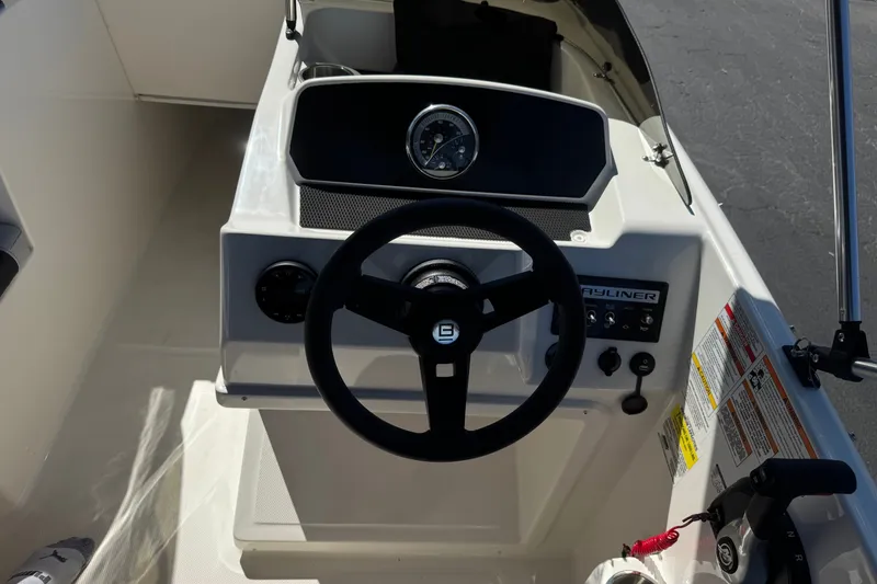 Slide: The Image of 2023 Bayliner Element M17 boat dashboard with steering wheel and controls. - 24