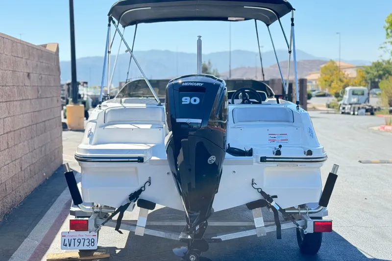 Slide: The Image of 2023 Bayliner Element M17 boat with Mercury 90 engine on trailer, parked outdoors. - 4