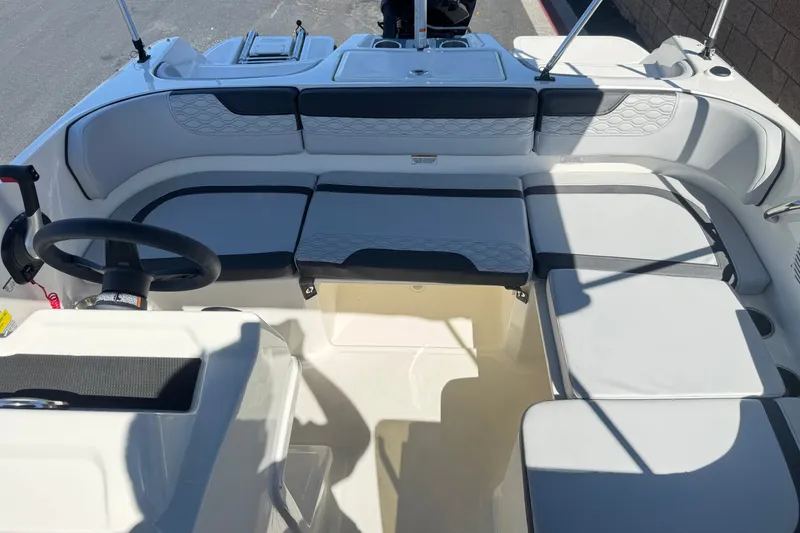 Slide: The Image of 2023 Bayliner Element M17 boat interior with seating and steering wheel. - 17
