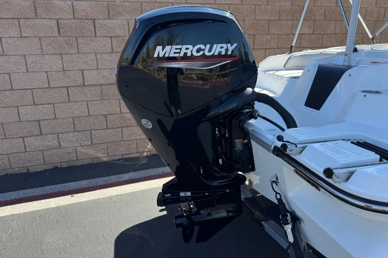 Slide: The Image of 2023 Bayliner Element M17 with Mercury outboard motor, parked near a brick wall. - 6