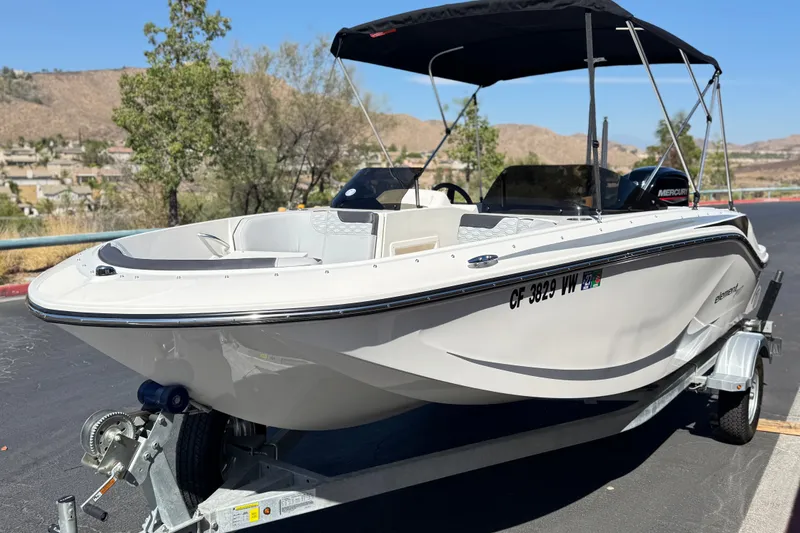 Slide: The Image of 2023 Bayliner Element M17 boat on trailer, parked outdoors with scenic background. - 3