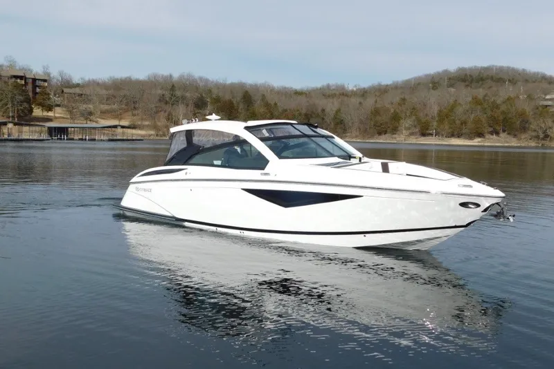The Image of 2019 Cobalt A36BR boat on a calm lake with wooded shoreline. - 0