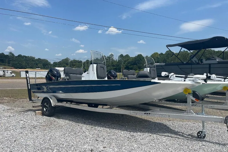 The Image of 2027 Xpress H20 Bay boat on trailer, parked outdoors under clear sky. - 1