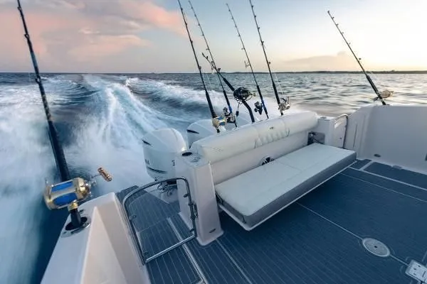 Slide: The Image of 2021 Regal 38 SAV boat with fishing rods, cruising on open water at sunset. - 18