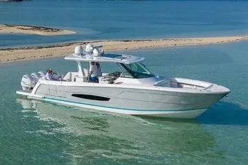 Slide: The Image of 2021 Regal 38 SAV boat cruising in clear turquoise waters near a sandy beach. - 30