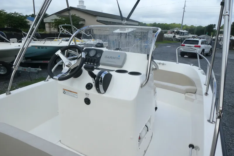 Slide: The Image of 2017 Boston Whaler 170 Dauntless boat interior with steering wheel and Garmin navigation system. - 7